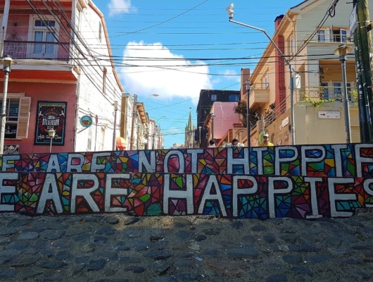 Peinture murale street art Valparaiso, Chili. Nous ne sommes pas des hippies, nous sommes des "happies", la joie de vivre à la chilienne. Agence locale Chili.
