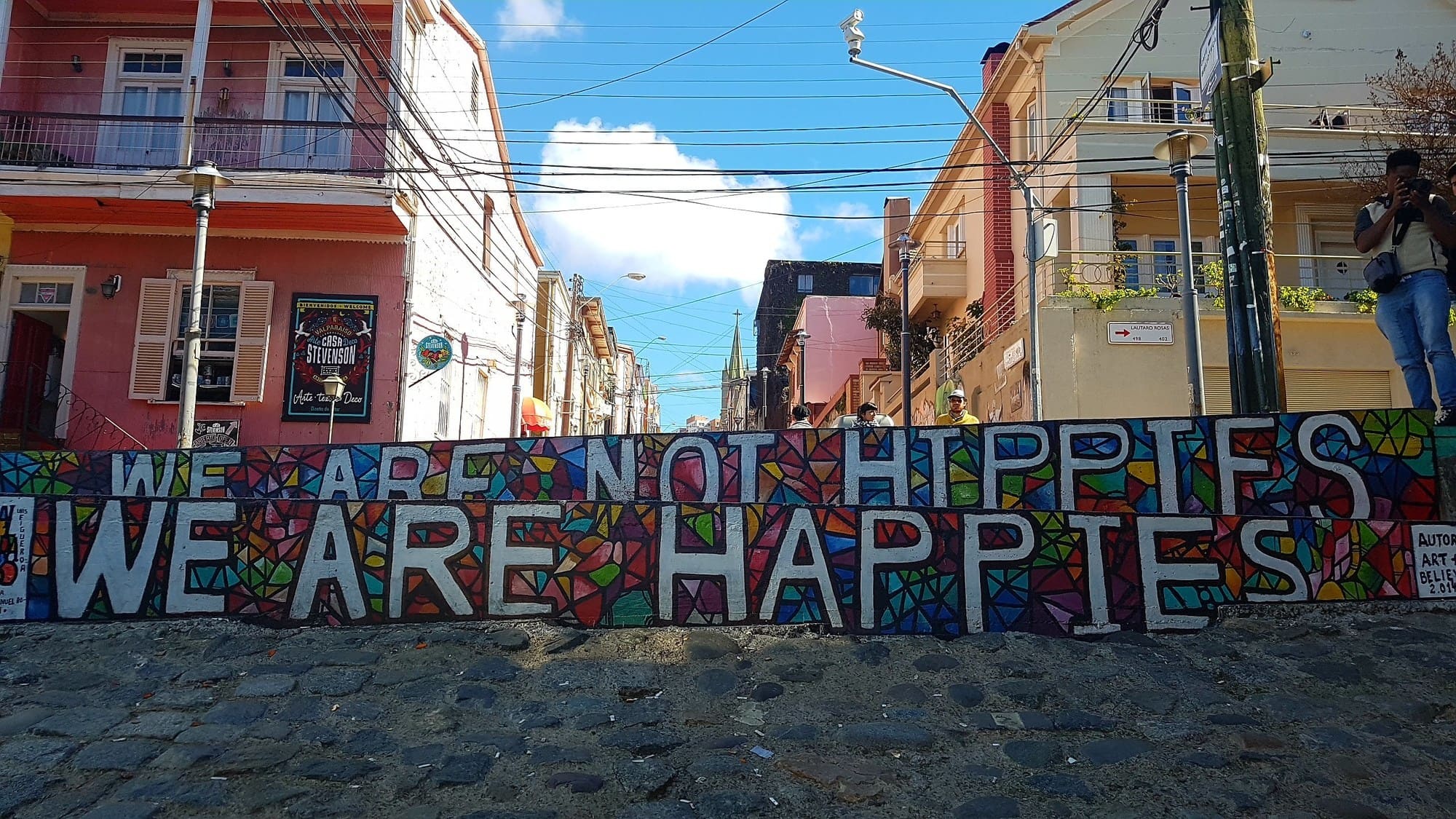 Peinture murale street art Valparaiso, Chili. Nous ne sommes pas des hippies, nous sommes des "happies", la joie de vivre à la chilienne. Agence locale Chili.
